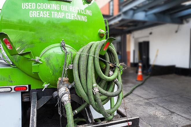 a technician pumping a grease trap in a commercial building in Media